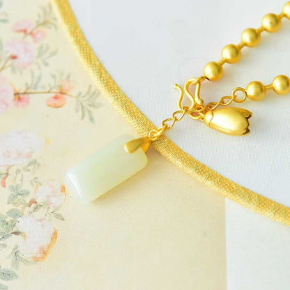 سوار من اليشم هتيان مرصع بالفضة عيار 925، مع خرزات فضية مستطيلة الشكل على شكل طبول مزدوجة وخردة فضية عادية.