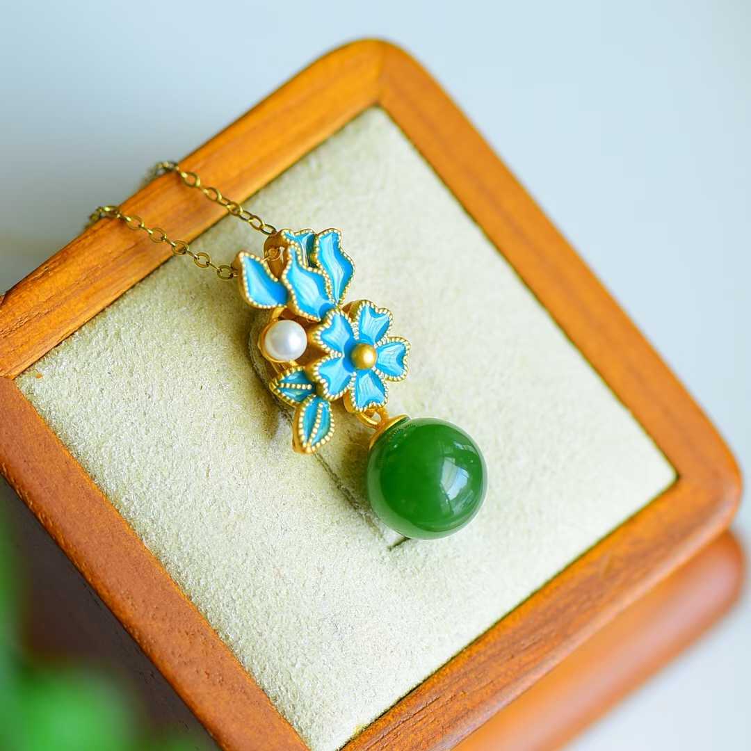 Close-up of enamel flower design with translucent green jade beads in luxurious gold finish