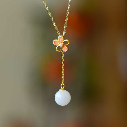 Close-up of cherry blossom enamel design with white nephrite beads in gilt silver setting